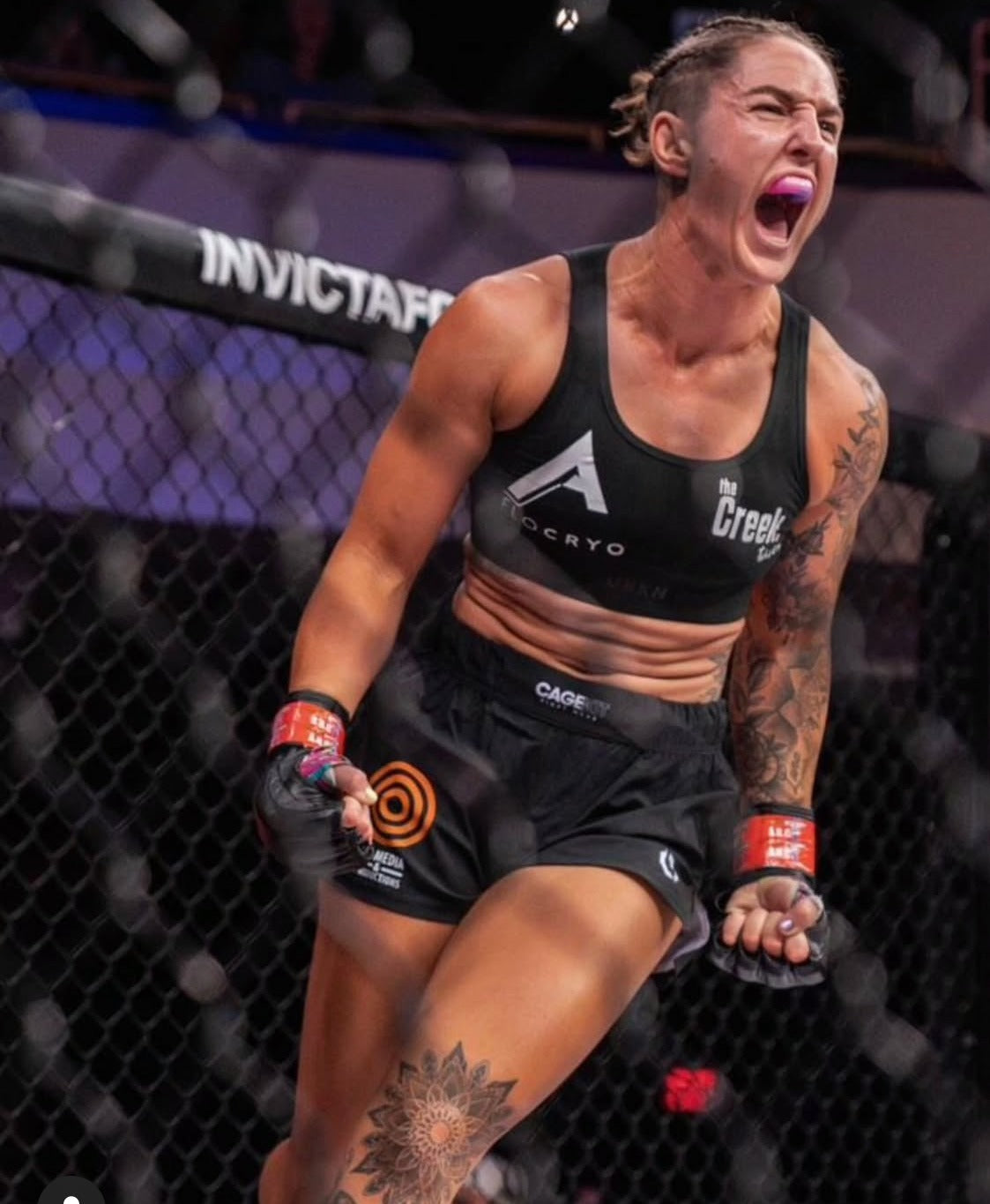 Australian MMA fighter Jamie Edenden celebrating in the cage at Invicta FC