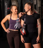 Women’s boxing gloves for women, two women in a gym holding gloves after training